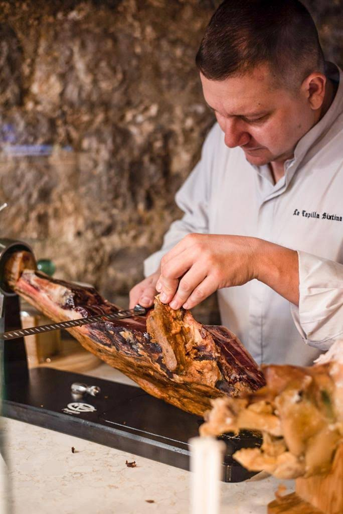 Traditional Iberian jamón being hand-carved